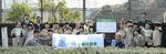 事業について表示された看板と記念撮影
