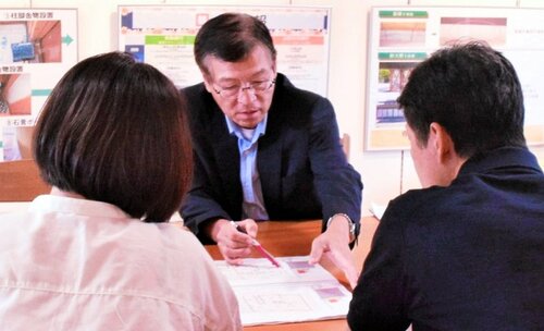 相談者に図面を示し耐震リフォームについて説明する小笹社長（中央）