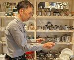 　商品の鍋を手に取る創業４６５年の老舗調理器具専門店「鍋屋」店主の水野文雄さん＝２０２４年６月、名古屋市