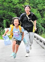 大学生（右）と一緒に下校する大山小の児童