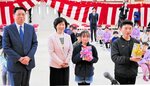 創価学会から贈られた本を掲げる児童