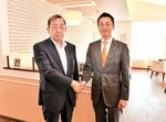 業務提携によりオープンする店舗で握手を交わす藤山社長（左）と奥村社長