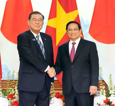 　会談を前に、ベトナムのファム・ミン・チン首相（右）と握手する石破首相＝２８日、ハノイ（共同）