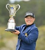 　通算１０アンダーでツアー初優勝を果たし、トロフィーを手に笑顔の工藤遥加＝ＵＭＫＣＣ