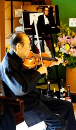 伊福部氏（奥の写真）が手がけた名曲を披露する小林さん＝１日、鳥取市河内の伊福部昭記念館