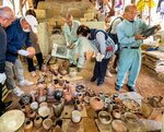 窯から出した作品の出来栄えを確かめる住民ら