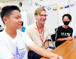 講師（中央）と一緒に英語で会話を楽しむ参加者ら