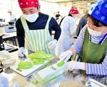 皮をむいた青パパイアをスライスする参加者