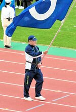 県旗を掲げ、堂々と行進する旗手の影井弘雄＝鹿児島市白波スタジアム