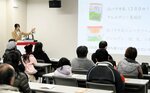 職員（左奥）から商品説明を受ける参加者ら