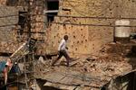 　１０日、カシミール地方のインド側支配地域で、パキスタン軍の攻撃後にがれきの中を歩く男性（ロイター＝共同）
