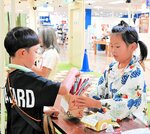 くじ引き屋で接客する子ども（右）＝１７日、倉吉市山根のパープルタウン