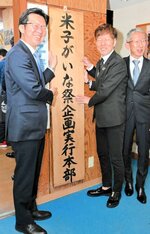 本部の看板を取り付ける（左から）伊木市長、村上本部長、永井実行委員長＝１０日、米子市道笑町１丁目のＢＭＥビル