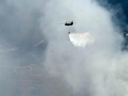 　愛媛県今治市の山林火災現場で消火活動する陸上自衛隊のヘリコプター＝２４日（防衛省統合幕僚監部提供）