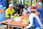仲間と弁当を食べながら一休み