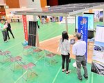 太陽光発電パネルを屋根にしたカーポート（手前）など省エネ、リフォームを手がける約２０社が出展する会場
