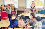ひな人形を飾った会場で合唱やカラオケ、ゲームなどで盛り上がる参加者＝１日、香美町村岡区福岡の兎塚地区公民館