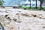 佐治川を勢いよく流れる濁流＝１５日午前１０時２１分、鳥取市佐治町福園