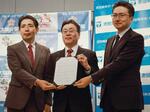　締結式で写真に納まる池田泉州銀行の藤原孝嘉取締役常務執行役員（中央）ら＝２６日、大阪府警本部