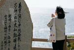 　慰霊祭の後、海に向かって手を合わせる女性＝７日午後、鹿児島県枕崎市