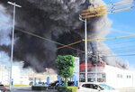 黒煙を上げて燃える建物＝３０日午前１０時５７分、鳥取県米子市両三柳