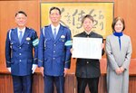 辻口調査官（左端）から賞状を受け取った山根さん（右から２人目）＝１３日、香美町村岡区の村岡高