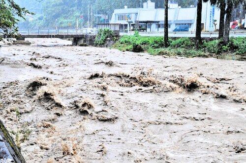 佐治川を勢いよく流れる濁流＝１５日午前１０時２１分、鳥取市佐治町福園