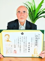 「白鳥省吾賞」最優秀賞の賞状を手にする足立さん＝２７日、境港市内