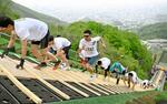 　札幌市の大倉山ジャンプ競技場で、ラージヒルを駆け上がる参加者＝１７日午前