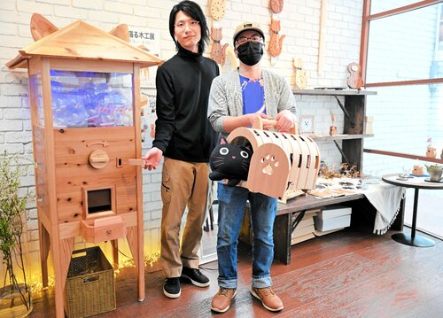 多彩な猫モチーフの木工作品を展示する草刈さん（右）と表さん