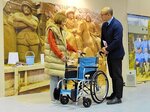 車いすを贈る徳田会長（左）