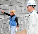 進入路の土留めのために造った壁について説明を受ける住民（左）＝２６日、新温泉町内山