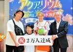 吉岡社長（右）から祝福を受ける畑中礼夢さんと両親＝３０日、境港市の夢みなとタワー