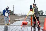 　石川県輪島市の「朝市通り」周辺で測量する関係者＝１５日午後
