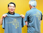 月山富田城をデザインしたポロシャツをＰＲする安来市観光協会関係者