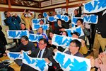 １３勝目を挙げて琴ノ若関の大関昇進が確実となり、名入れタオルを掲げて喜ぶ後援会関係者ら＝２８日、倉吉市魚町の琴桜記念館
