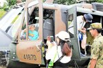 陸上自衛隊のヘリコプターに体験搭乗する親子＝１５日、琴浦町田越の東伯総合公園