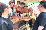 自家焙煎コーヒーを楽しむ来場者と店主（中央）