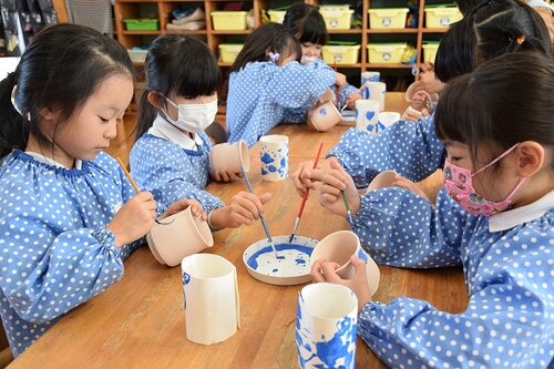 真剣な表情で絵付けをする園児たち＝４日、米子市夜見町のかもめ幼稚園