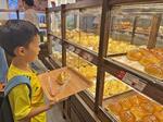 　シンガポール中心部オーチャードの「五穀七福」の店舗で商品を選ぶ男の子＝２０２４年４月１６日（共同）