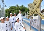 設置された校章を見つめる硬式野球部員ら＝米子市勝田町の米子東高