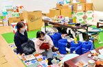 避難所で孫とくつろぐ平野さん（左）＝１月１７日、石川県志賀町代田の旧土田小