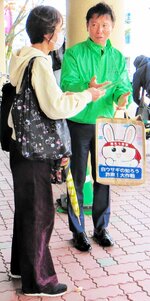特殊詐欺防止の啓発チラシを市民に手渡す生保協会員（右）