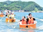 バランスを取りながら、たらいをこぎ進める出場者＝２７日、香美町香住区七日市の香住浜海水浴場