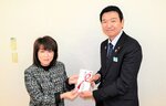 草刈常務理事（右）から寄付金の目録を受け取る稲村理事長
