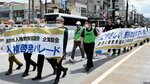 横断幕を掲げ、商店街をパレードする参加者＝９日、鳥取市の本通り商店街
