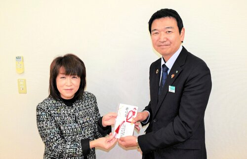 草刈常務理事（右）から寄付金の目録を受け取る稲村理事長