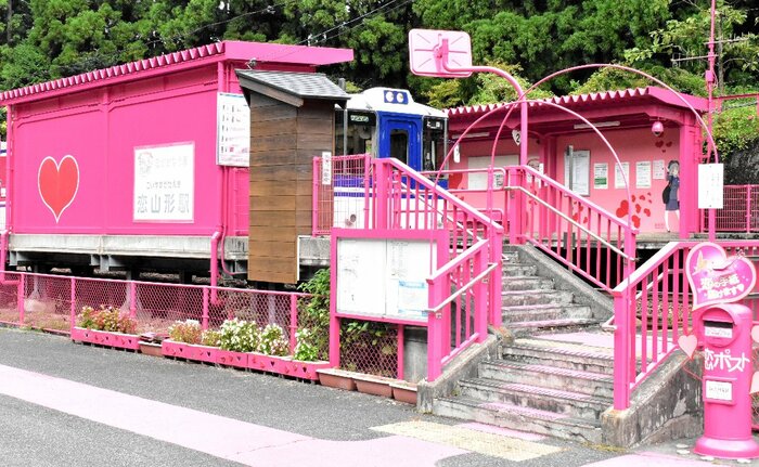 鮮やかなピンク色に塗装された恋山形駅