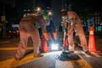 　マレーシア・クアラルンプールで道路の穴を修復する勝手連「兄弟」のメンバーら＝２０２４年４月（共同）