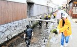 川の底にある藻を協力して取り除く会員ら